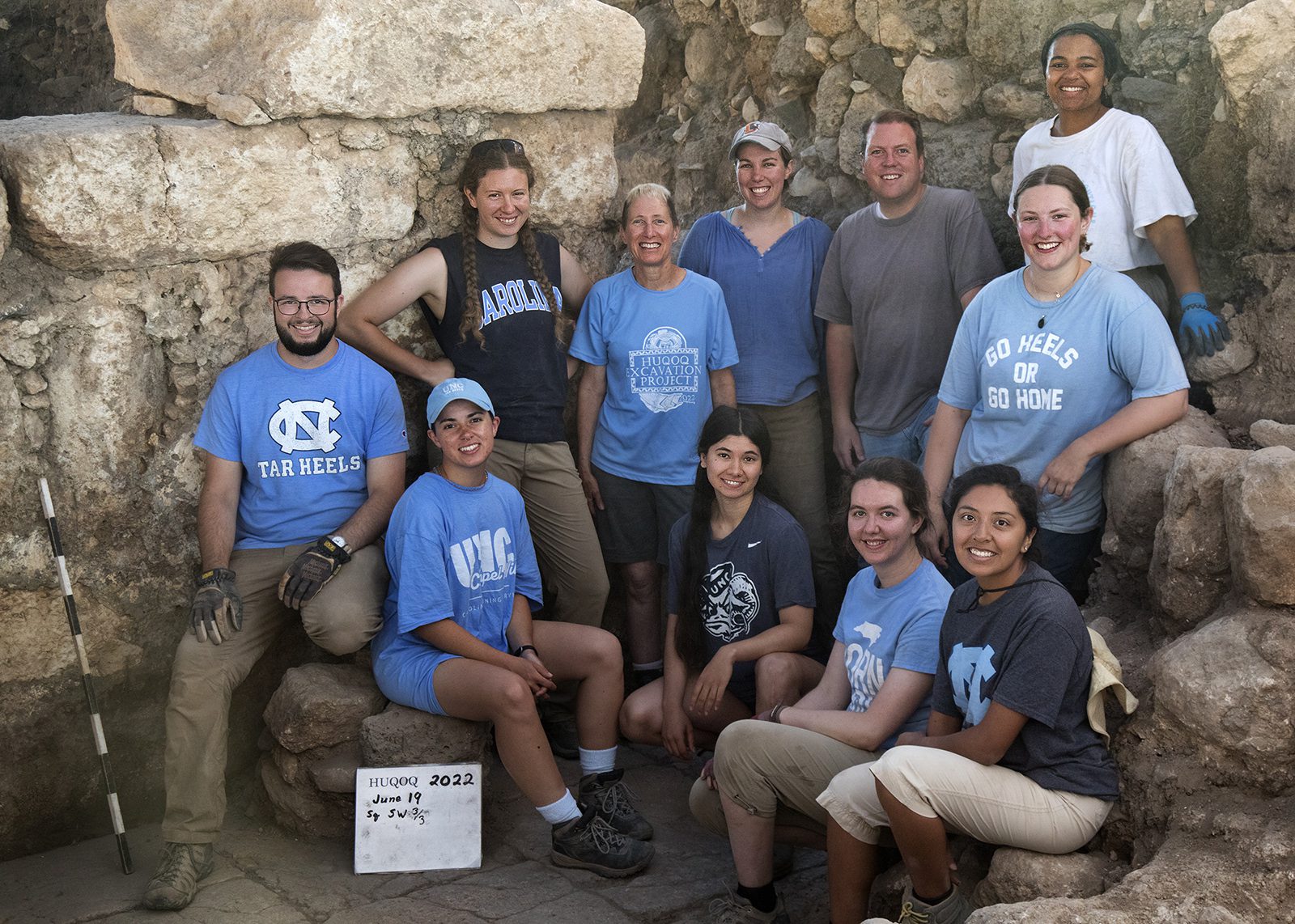 UNC-Chapel Hill excavation participants at the Huqoq dig in June 2022, including graduate students and alumni. Bottom row from left to right (seated): David Richman; Christine Stamey; Aislynn Grantz; Madison Brinkley; Suzy Lagunas. Top row from left to right (standing): Emily Branton; Jodi Magness; Jocelyn Burney; Matthew Grey; Grace Curry; Jada Enoch (top right). Photo © Jim Haberman