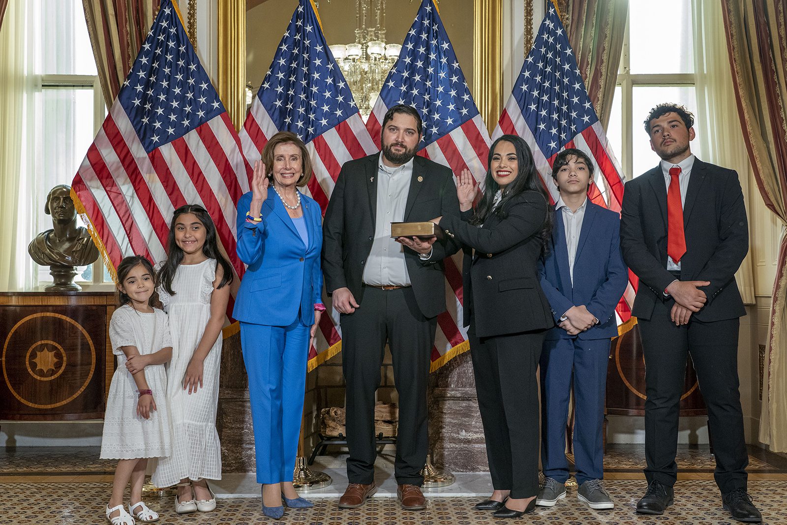 House Speaker Nancy Pelosi administers the House oath to Rep. Mayra Flores, R-Texas, right as her husband John holds the Bible, during a mock swearing in ceremony at the Capitol in Washington, Tuesday, June 21, 2022, with children, from left, Milani, 6, Maite, 8, Jaden, 12, and John Michael, 16. (AP Photo/Gemunu Amarasinghe)