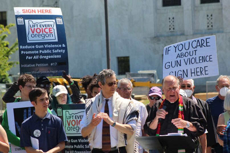 The Rev. Mark Knutson, right, chief petitioner of a gun initiative, speaks at a rally, joined by Rabbi Michael Cahana, center, outside the Oregon Capitol in Salem before signatures are delivered to state elections officials to get the proposal on the ballot, on July 8, 2022. Oregonians will decide in November whether people wanting to purchase a gun must first qualify for a permit, after one of the strictest gun control measures in the nation was approved to get on the ballot. (AP Photo/Andrew Selsky,File)