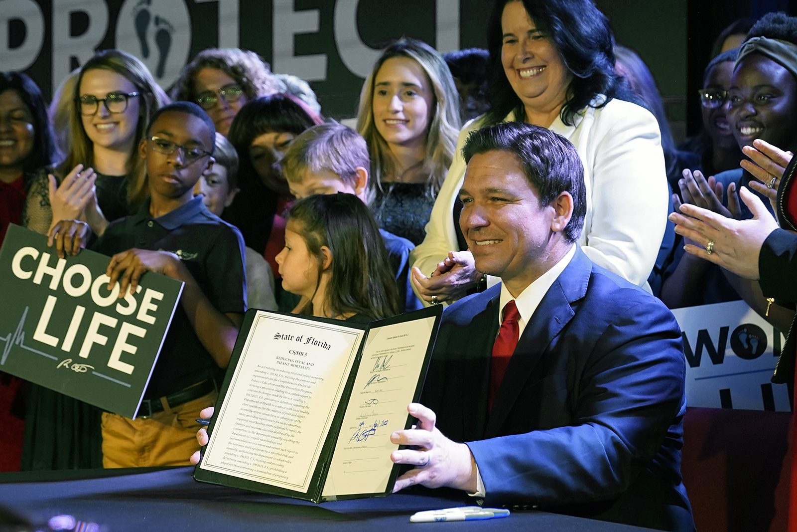 Florida Gov. Ron DeSantis holds up a 15-week abortion ban law after signing it on April 14, 2022, in Kissimmee, Fla. (AP Photo/John Raoux)