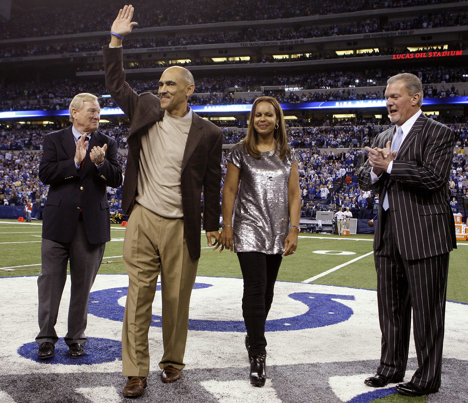 Former Indianapolis Colts coach Tony Dungy and his wife, Lauren, walk off the field after Dungy was inducted into the Colts Ring of Honor during an NFL football game in Indianapolis, Monday, Nov. 1, 2010. Indianapolis Colts president Bill Polian is at left, while Colts owner Jim Irsay is at right. (AP Photo/Darron Cummings)