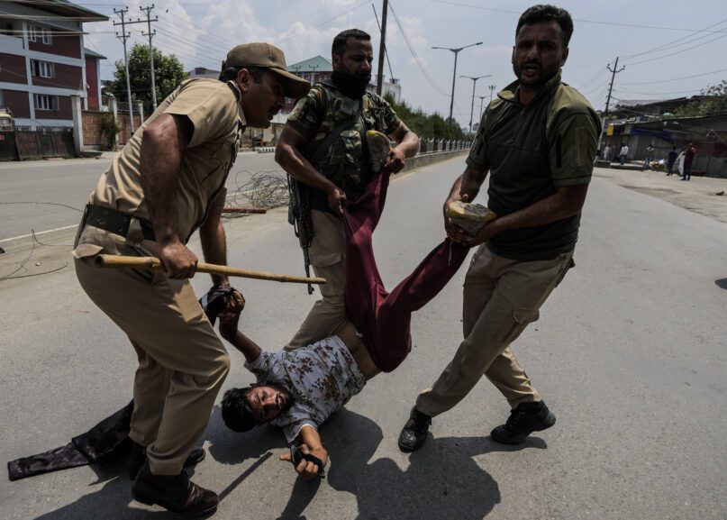 Indian policemen detain a Kashmiri Shiite Muslim for participating in a religious procession during restrictions in Srinagar, Indian controlled Kashmir, Sunday, Aug. 7, 2022. Authorities had imposed restrictions in parts of Srinagar, the region's main city, to prevent gatherings marking Muharram from developing into anti-India protests. (AP Photo/Mukhtar Khan)