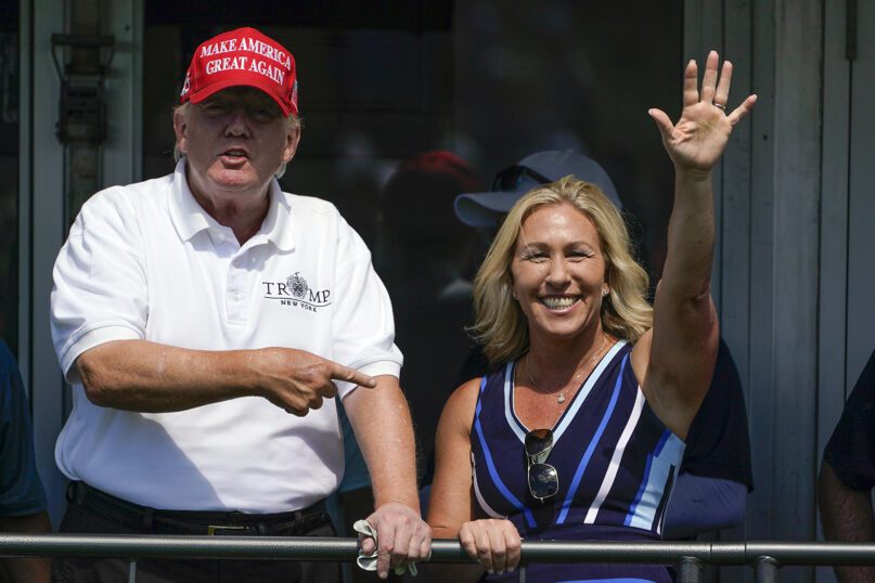 Rep. Marjorie Taylor Greene, R-Ga., waves while former President Donald Trump points to her while they look over the 16th tee during the second round of the Bedminster Invitational LIV Golf tournament in Bedminster, N.J., July 30, 2022. (AP Photo/Seth Wenig, File)