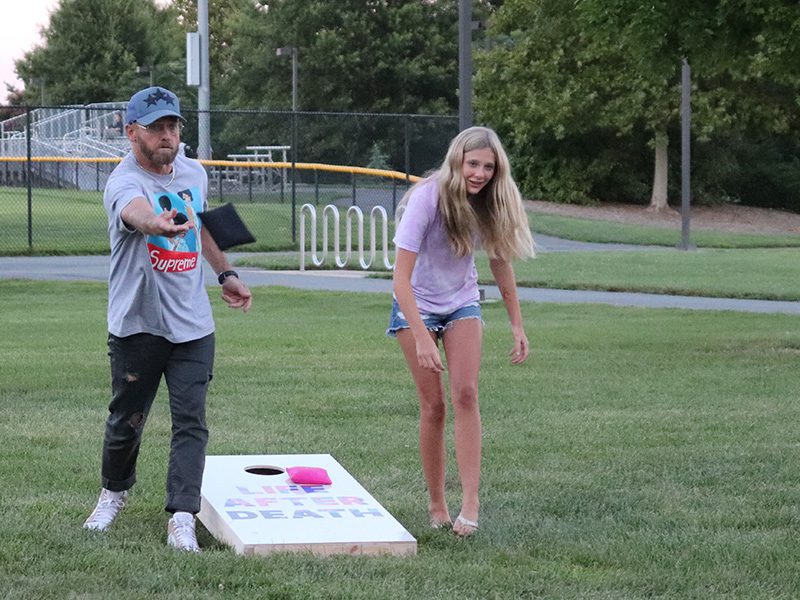 Musician TobyMac, left, plays cornhole with Leah Bruck, right, of Frederick, Maryland, after a radio station visit in Rockville, Maryland, Thursday, Aug. 18, 2022. RNS photo by Adelle M. Banks