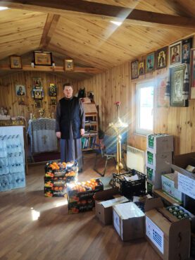 Fr. Berezhnoy with food aid inside the church in March 2022. Photo courtesy of Kyiv Saints Cathedral