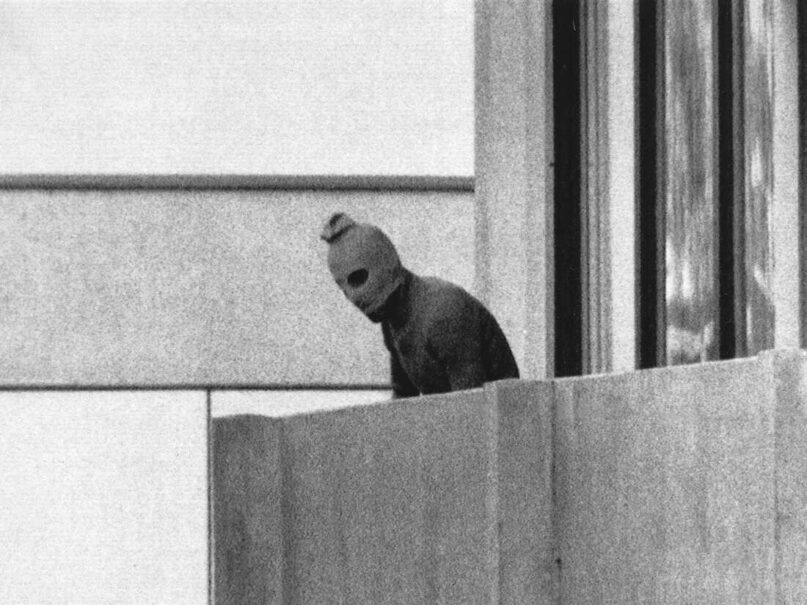 In this file photo from Sept. 5, 1972, a member of the Arab commando group that seized members of the Israeli Olympic team at their quarters at the Munich Olympic Village appears with a hood over his face on the balcony of the village building where the commandos held several members of the Israeli team hostage. (AP Photo/Kurt Strumpf, File)