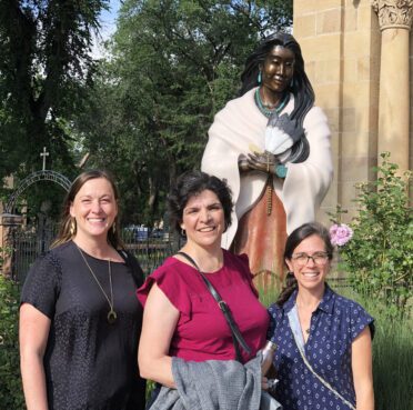 Lisa Amman, Ellie Hidalgo and Casey Stanton gathered together for the first time last July in New Mexico to begin work planning. The group posed with a statue of St. Kateri Tekakwitha. Photo courtesy of Ellie Hidalgo