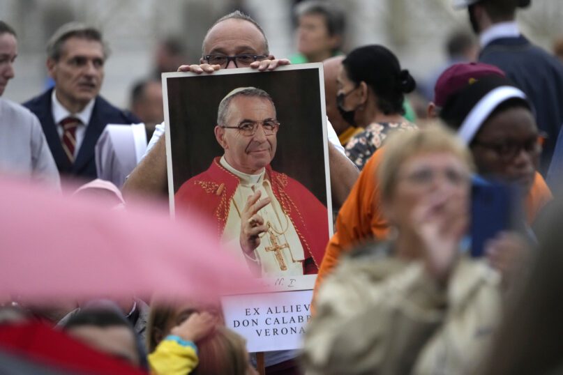 A man holds a photo of Pope John Paul I during the beatification ceremony led by Pope Francis in St. Peter's Square at the Vatican. (AP Photo/Andrew Medichini)