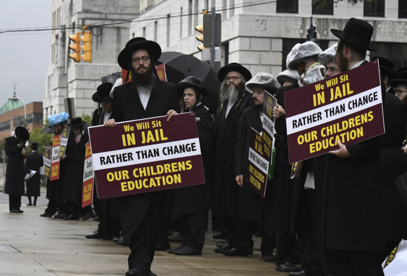 Members of the ultra-Orthodox and Hasidic Jewish communities hold a protest before a board of regents meeting to vote on new requirements that private schools teach English, math, science and history to high school students, Sept. 12, 2022, outside the New York state Education Department building in Albany, New York. Leaders of the Hasidic schools say the regulations would eliminate their schools where male students regularly study just the Talmud. Educators say the change will require private schools to provide a basic high school education. (Will Waldron/The Albany Times Union via AP)