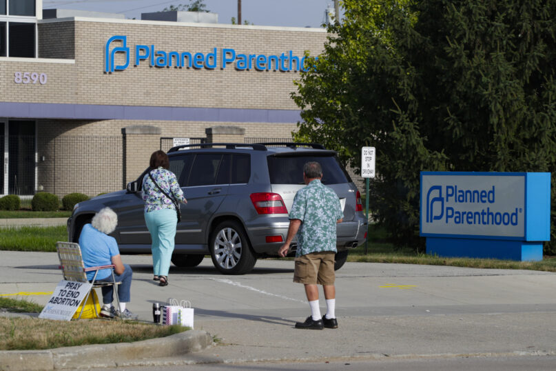 Abortion protesters attempt to hand out literature as they stand in the driveway of a Planned Parenthood clinic in Indianapolis on Aug. 16, 2019. (AP Photo/Michael Conroy, File)