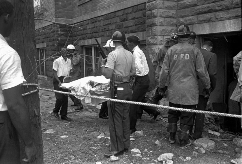 FILE - Firemen and ambulance attendants remove a covered body from Sixteenth Street Baptist Church, where an explosion ripped the structure during services, killing four black girls, on Sept. 15, 1963. Sarah Collins Rudolph lost an eye and has pieces of glass inside her body from a Ku Klux Klan bombing that killed her sister and three other Black girls inside an Alabama church 59 years ago. (AP Photo, File)