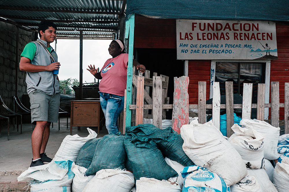 El trabajador social de Tierra Grata, Luis Castellanos Otero, habla con la residente local Merlys Voldez durante una visita al barrio Isla de León de Cartagena, Colombia, en mayo de 2022.  Foto por Noel Rojo