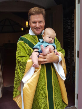 The Rev. Vincent “Chip” Seadale holds his grandson at St. Andrews Episcopal Church in Edgartown, Mass. Photo courtesy of Chip Seadale