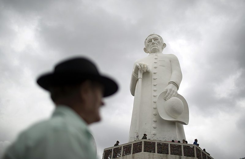 In this Oct. 31, 2015 photo, a statue of Padre Cicero, or Padim Ciço, a late Brazilian priest who's venerated as a saint locally but not recognized as one by the Roman Catholic Church, stands tall in Juazeiro do Norte, Brazil. People line up to touch the statue, some praying on their knees before it. Others leave letters of gratitude to him, who they credit with miracles. (AP Photo/Leo Correa)