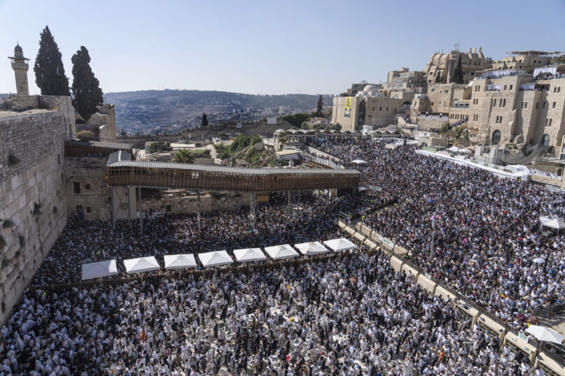Jewish men pray as they attend a blessing ceremony during the Jewish holiday of Sukkot at the Western Wall, the holiest site where Jews can pray, in the Old City of Jerusalem, Wednesday, Oct. 12, 2022. (AP Photo/Tsafrir Abayov)