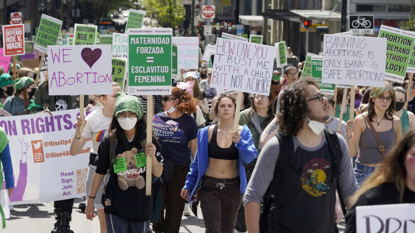 Protesters carry signs in English and Spanish during a march in favor of abortion rights, Saturday, May 14, 2022, in downtown Seattle. (AP Photo/Ted S. Warren)