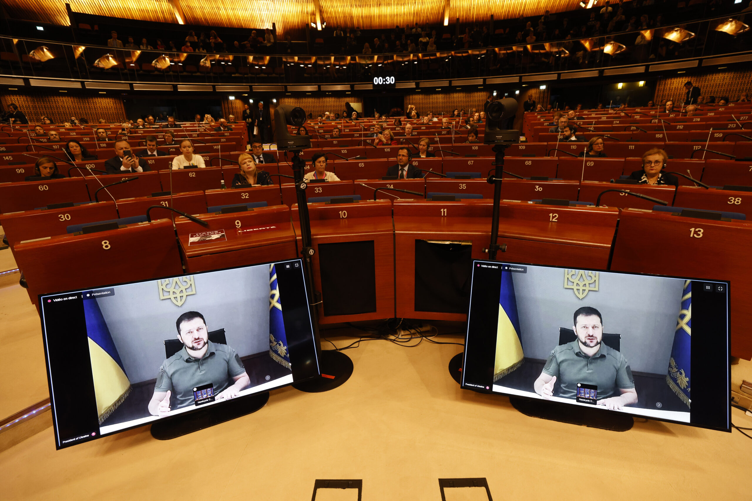 Ukrainian President Volodymyr Zelenskyy speaks during a video address to the European Council, Thursday, Oct. 13, 2022 in Strasbourg, eastern France. Ukraine's capital region was struck by Iranian-made kamikaze drones early Thursday, officials said, sending rescue workers rushing to the scene as residents awoke to air raid sirens for the fourth consecutive morning following Russia's major assault across the country earlier this week. (AP Photo/Jean-Francois Badias)