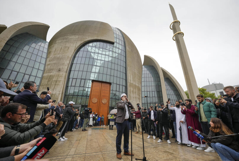 Muezzin Mustafa Kader recites the call to prayer at the Cologne Central Mosque in Cologne, Germany, Friday, Oct. 14, 2022. The Islamic call to prayer is set to sound for the first time from one of Germany’s biggest mosques in Cologne on Friday — but at limited volume. It is part of a project agreed with authorities in the city that has one of the country’s biggest Muslim communities. (AP Photo/Martin Meissner)