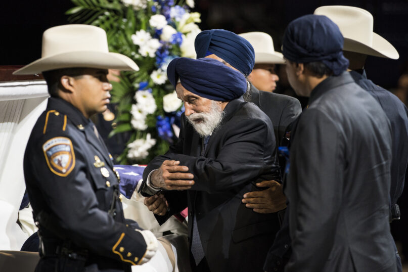 FILE - Pyara Singh Dhaliwal, father of Harris County Sheriff's Deputy Sandeep Dhaliwal, center, pays respects to his son during his funeral at Berry Center on Oct. 2, 2019, in Houston. A man was convicted of capital murder on Monday, Oct. 17, 2022, in the 2019 shooting death of the law enforcement officer who was the first Sikh deputy in his Texas agency. (Brett Coomer/Houston Chronicle via AP, File)