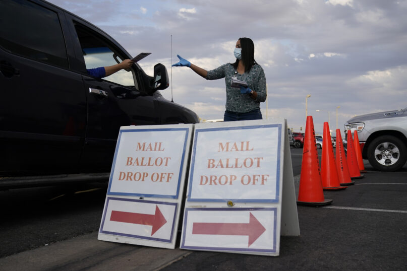 A county worker collects mail-in ballots in a drive-thru mail-in ballot drop-off area at the Clark County Election Department, Nov. 2, 2020, in Las Vegas. (AP Photo/John Locher, File)