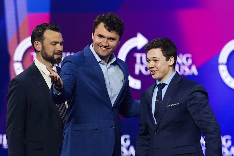 Kyle Rittenhouse, right, is introduced to a cheering crowd by Charlie Kirk, middle, founder of Turning Point USA, at a panel discussion at the Turning Point USA America Fest 2021 event, Monday, Dec. 20, 2021, in Phoenix. The panel discussion, called 