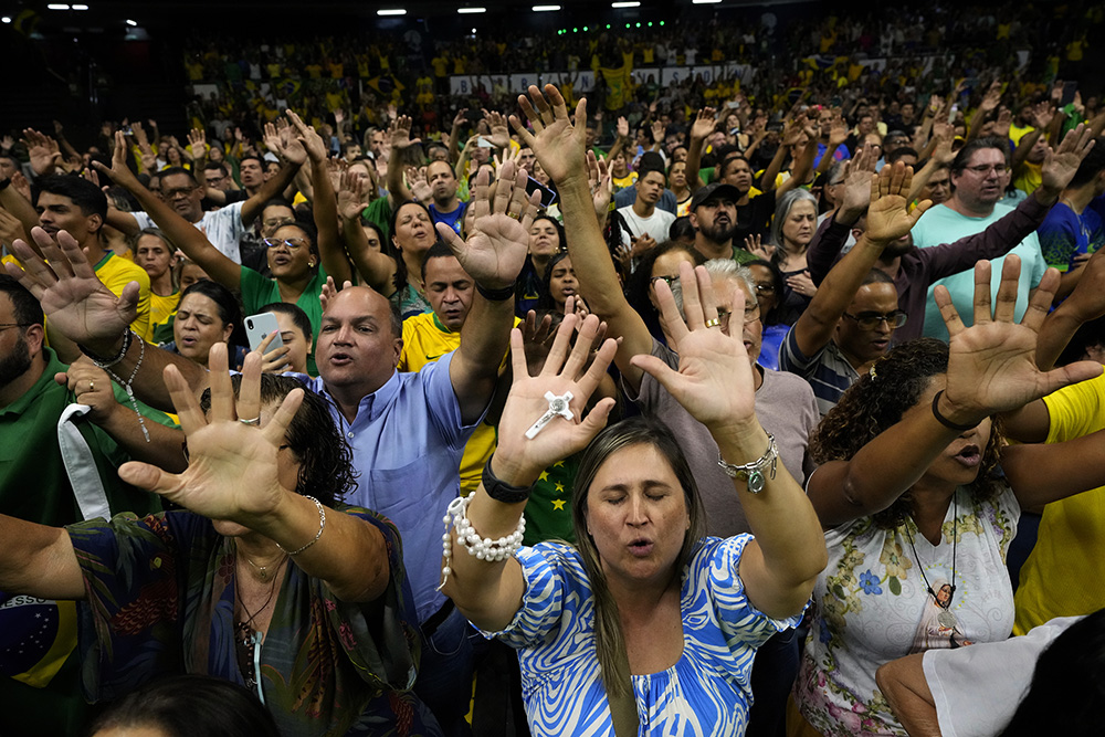 Catholics pray during a religious event in support of Brazil's President Jair Bolsonaro, who is running for re-election, in Brasilia, Brazil, Monday, Oct. 17, 2022. Bolsonaro will compete against former President Luiz Inacio Lula da Silva in a presidential runoff election on Oct. 30. (AP Photo/Eraldo Peres)