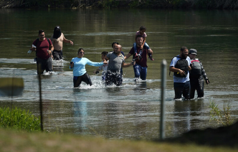A group of migrants mainly from Venezuela wades through the Rio Grande to cross the U.S.-Mexico border, June 16, 2021, in Del Rio, Texas. The Biden administration has agreed to accept up to 24,000 Venezuelan migrants, similar to how Ukrainians have been admitted after Russia’s invasion, while Mexico has agreed to accept some Venezuelans who are expelled from the United States, the two nations said Oct. 12, 2022. (AP Photo/Eric Gay)