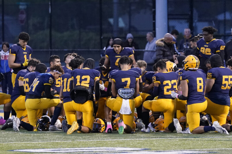 Dearborn Fordson High School receiver Hassan Shinawah leads the team in prayer before its game against Dearborn High School, Friday, Oct. 14, 2022 in Dearborn, Mich. It was the only time this season that the team held its prayer outside the locker room and only because Senior Day festivities and pregame messages from coaches ran long. (AP Photo/Carlos Osorio)