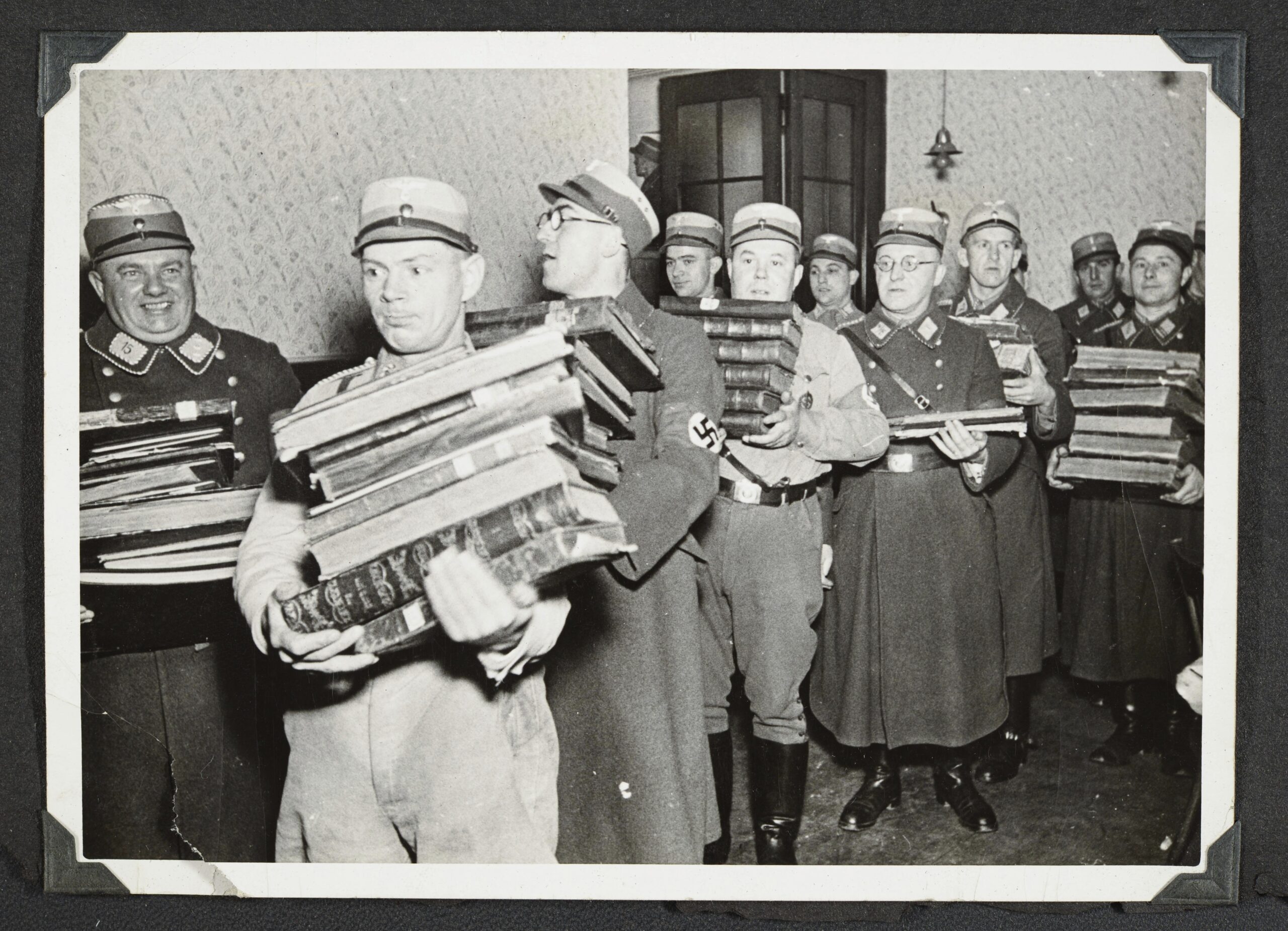 This photo released by Yad Vashem, World Holocaust Remembrance Center, shows German Nazis carry Jewish books, presumably for burning, during Kristallnacht intake most likely in the town of Fuerth, Germany on Nov. 10, 1938. The photos were taken by Nazi photographers during the pogrom in the city of Nuremberg and the nearby town of Fuerth. They wound up in the possession of a Jewish American serviceman who served in Germany during World War II. His descendants,donated the album to Yad Vashem. (Yad Vashem via AP)
