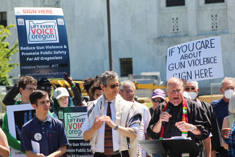 The Rev. Mark Knutson, right, chief petitioner of a gun initiative, speaks at a rally, joined by Rabbi Michael Cahana, center, outside the Oregon state Capitol in Salem on July 8, 2022, before signatures are delivered to Oregon elections officials to get the proposal on the ballot. (AP Photo/Andrew Selsky,File)