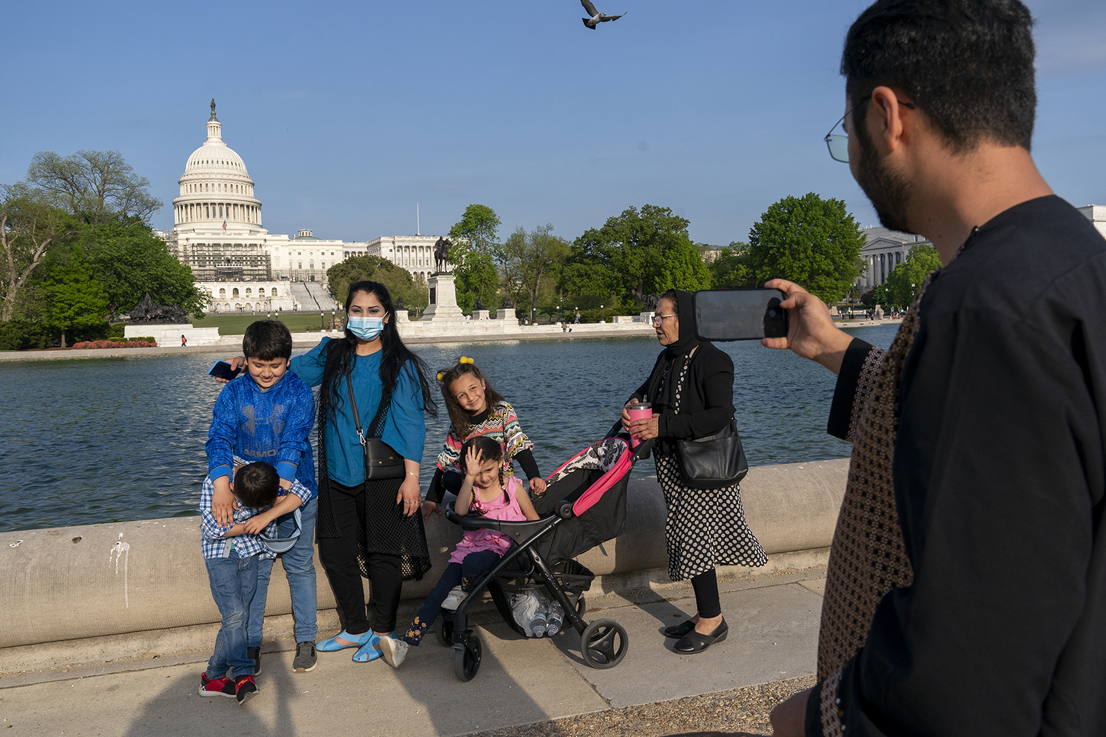 The Safi family celebrates Eid by taking family photographs on the National Mall, May 3, 2022, near the U.S. Capitol in Washington. The family was evacuated from Afghanistan and is trying to make a new life in the U.S., while in immigration limbo. (AP Photo/Jacquelyn Martin)