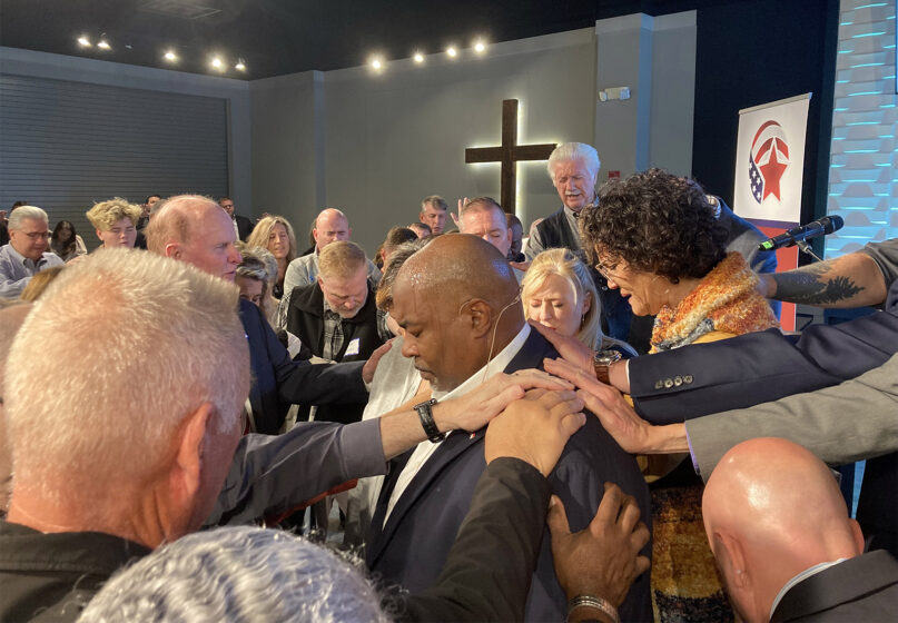 At each American Renewal Project pastor luncheon in North Carolina, pastors are asked to lay hands on and pray for Lt. Gov. Mark Robinson, center, as they do here on Oct. 31, 2022, in Jamestown, N.C. The American Renewal Project, which tries to mobilize pastors to run for office, held eight pastor luncheons across North Carolina this fall. RNS photo by Yonat Shimron