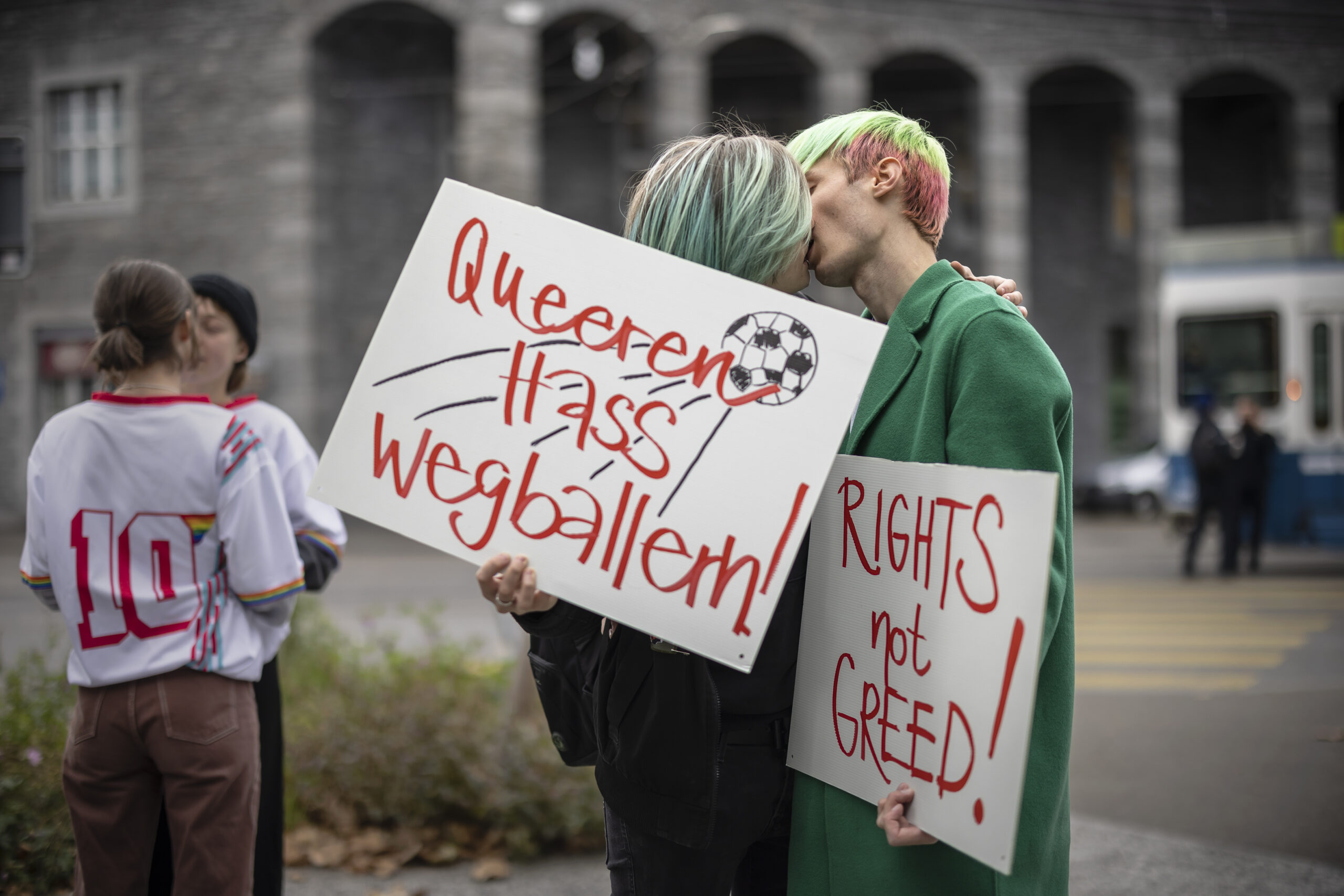 FILE - Protestors kiss while holding placards reading "Shoot out queer hate" and "Rights not greed" during a rally to raise awareness of the human rights situation of LGBTQ people in Qatar and FIFA's responsibility, in front of the FIFA Museum in Zurich, Switzerland, Tuesday, Nov. 8, 2022. An ambassador for the World Cup in Qatar has described homosexuality as a "damage in the mind" in an interview with German public broadcaster ZDF only two weeks before the opening of the soccer tournament in the Gulf state. (Michael Buholzer/Keystone via AP, File)