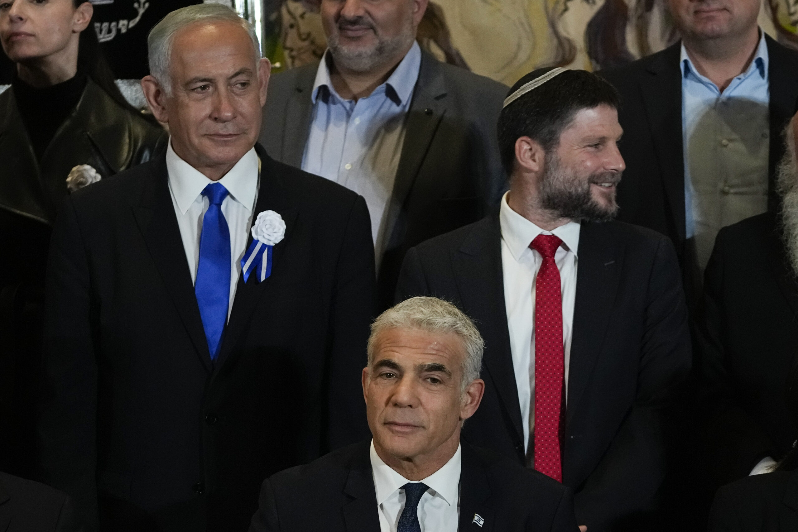 FILE-Israeli Prime Minister Yair Lapid, center, Likud Party leader Benjamin Netanyahu, left, far-right Israeli lawmaker Bezalel Smotrich and leaders of all Israel's political parties pose for a group photo after the swearing-in ceremony for Israeli lawmakers at the Knesset, Israel's parliament, in Jerusalem, Tuesday, Nov. 15, 2022. Israel's designated prime minister, Benjamin Netanyahu, has announced a coalition deal with a hardline pro-settler party on Thursday, Dec. 1, 2022. The agreement will give Religious Zionism control over a number of key government ministries and a senior post over West Bank settlement construction. (AP Photo/Tsafrir Abayov, File)