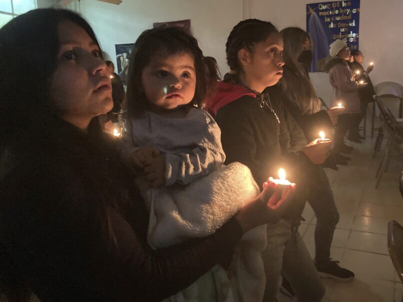 Guests at the Buen Samaritano shelter for migrants participate in a candle lighting ceremony in anticipation of Christmas in Ciudad Juárez, Mexico, across from El Paso, Texas, on Thursday, Dec. 22, 2022. Tens of thousands of migrants who fled violence and poverty will spend Christmas in crowded shelters or on the dangerous streets of Mexican border towns. The Biden administration asked the Supreme Court not to lift pandemic-era restrictions on asylum-seekers before the holiday weekend. (AP Photo/Morgan Lee)