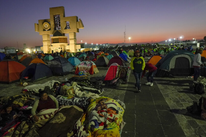 Pilgrims camp outside the Basilica of Guadalupe in Mexico City, early Monday, Dec. 12, 2022. Devotees of the Virgin of Guadalupe make the pilgrimage for her Dec. 12 feast day, the anniversary of one of several apparitions of the Virgin Mary witnessed by an Indigenous Mexican man named Juan Diego in 1531. (AP Photo/Aurea Del Rosario)