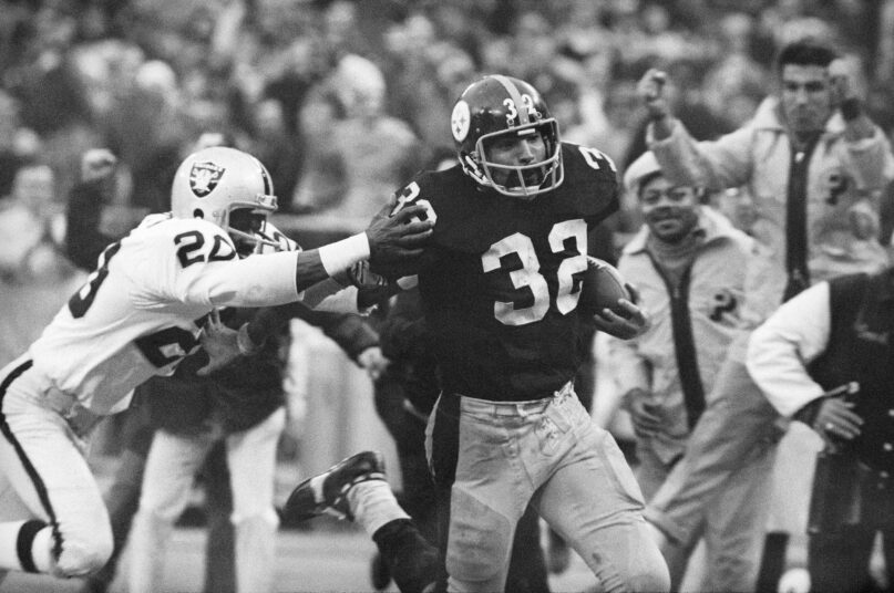 FILE - Pittsburgh Steelers' Franco Harris (32) eludes a tackle by Oakland Raiders' Jimmy Warren as he runs 42-yards for a touchdown after catching a deflected pass during an AFC Divisional NFL football playoff game in Pittsburgh, Dec. 23, 1972. Harris' scoop of a deflected pass and subsequent run for the winning touchdown — forever known as the 