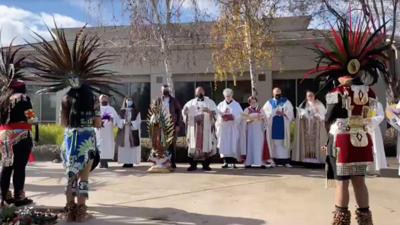 Aztec dancers bless a statue of the Virgin of Guadalupe, center, on Sunday, Dec. 11, 2022, before a service at Iglesia Luterana Santa María Peregrina in California’s Central Valley. Video screen grab