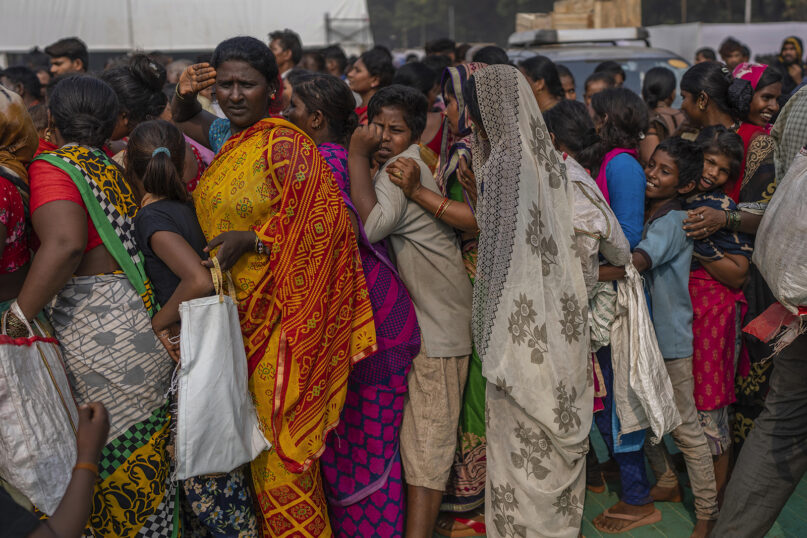 Indian women and children stand in line for free food distributed to mark Bhim Rao Ambedkar's death anniversary in Mumbai, India, Tuesday, Dec. 6, 2022. Ambedkar, an untouchable, or dalit, and a prominent Indian freedom fighter, was the chief architect of the Indian Constitution, which outlawed discrimination based on caste. (AP Photo/Rafiq Maqbool)