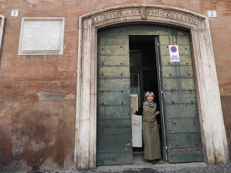 Artist Natalia Tsarkova poses in the door to her studio in Rome in early December 2022. RNS photo by Claire Giangravé