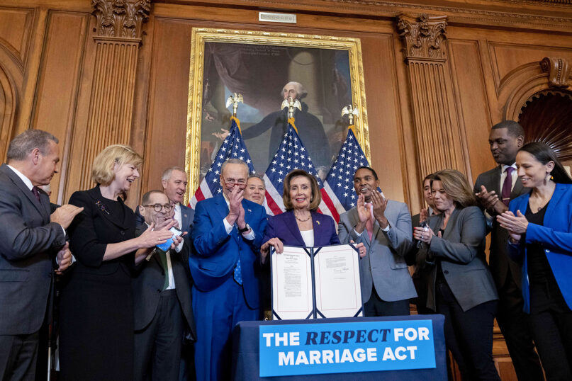 House Speaker Nancy Pelosi of California, center, accompanied by Senate Majority Leader Chuck Schumer of New York, center left, and other members of Congress, displays the signed H.R. 8404, the Respect for Marriage Act, on Capitol Hill in Washington, Dec. 8, 2022. (AP Photo/Andrew Harnik)