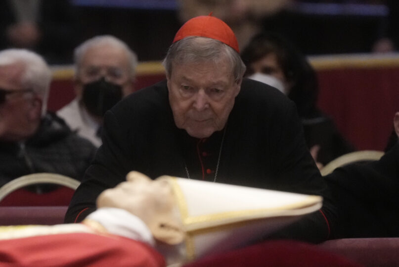 Australian Cardinal George Pell stands near the body of the late Emeritus Pope Benedict XVI lying in state inside St. Peter's Basilica at the Vatican, Jan. 3, 2023. Pell, who was the most senior Catholic cleric to be convicted of child sex abuse before his convictions were later overturned, died Jan. 10, 2023, in Rome at age 81. (AP Photo/Gregorio Borgia, File)