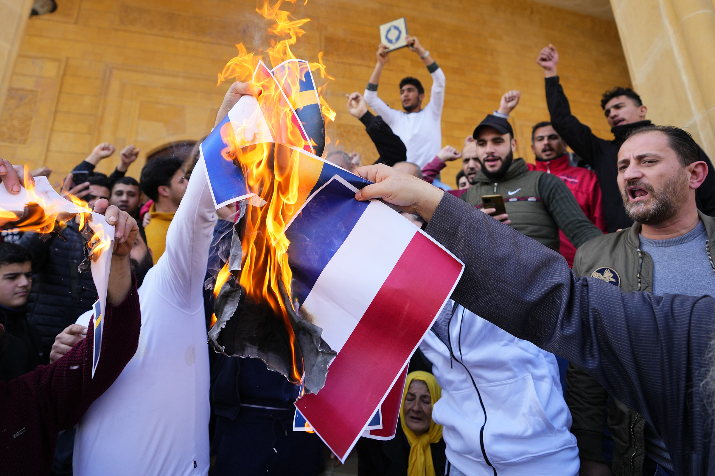 Scores of angry protesters burn the Swedish and Dutch flags after Friday prayers outside Mohammad al-Amin Mosque to denounce the recent desecration of Islam's holy book by a far-right activists in the European countries, in downtown Beirut, Lebanon, Friday, Jan. 27, 2023. Earlier this month, a far-right activist from Denmark staged a protest outside the Turkish Embassy in Stockholm where he burned the Quran, Islam's holy book. Days later, Edwin Wagensveld, Dutch leader of the far-right Pegida movement in the Netherlands tore pages out of a copy of the Quran near the Dutch parliament and stomped on the pages. (AP Photo/Hassan Ammar)