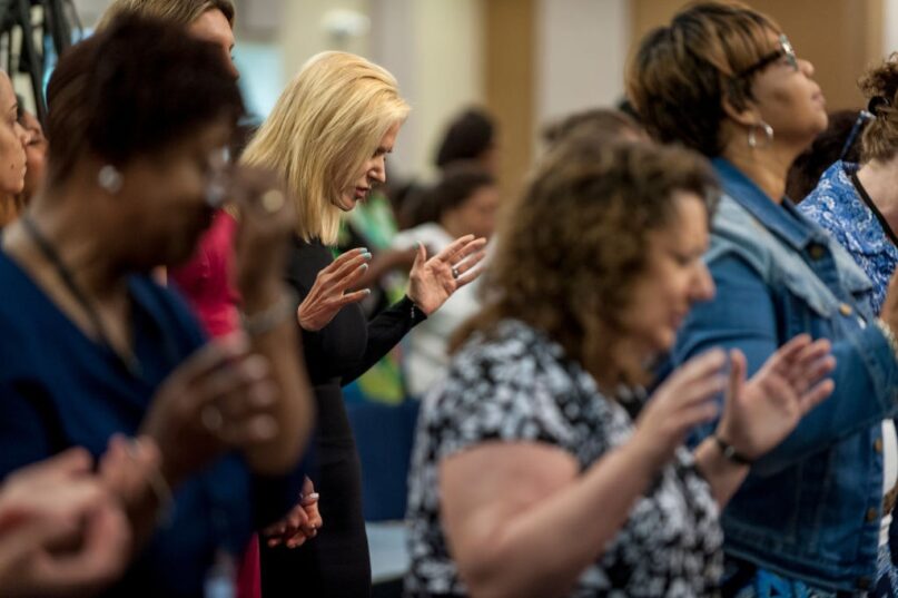 Pentecostal televangelist Paula White, center, prays before giving a sermon in Maryland in 2017. (Mary F. Calvert For The Washington Post via Getty Images)