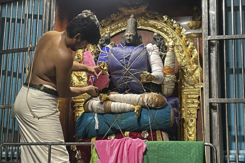 S. Goutham lays the foundation for an elaborate decoration of a deity at the Anantha Padmanabha Swamy Temple in Chennai, India, on Nov. 29, 2022. Goutham is a fifth-generation practitioner of this millennia-old spiritual art of decorating temple deities. (AP Photo/Deepa Bharath)