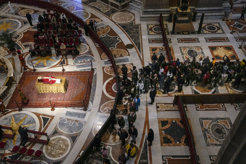 People queue to see the late Emeritus Pope Benedict XVI lying in state inside St. Peter’s Basilica at the Vatican, where thousands went to pay their homage, Jan. 3, 2023. Pope Benedict was a German theologian who will be remembered as the first pope in 600 years to resign. (AP Photo/Antonio Calanni)