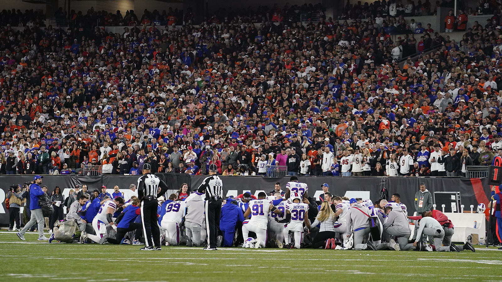 football players kneel in prayer on the field in Cincinnati