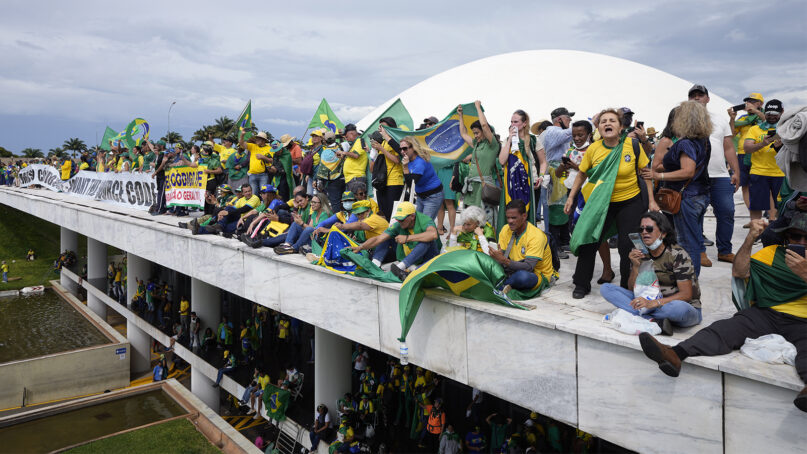 Supporters of Brazil's former President Jair Bolsonaro stand on the roof of the National Congress building after they stormed it, in Brasilia, Brazil, Jan. 8, 2023. (AP Photo/Eraldo Peres)