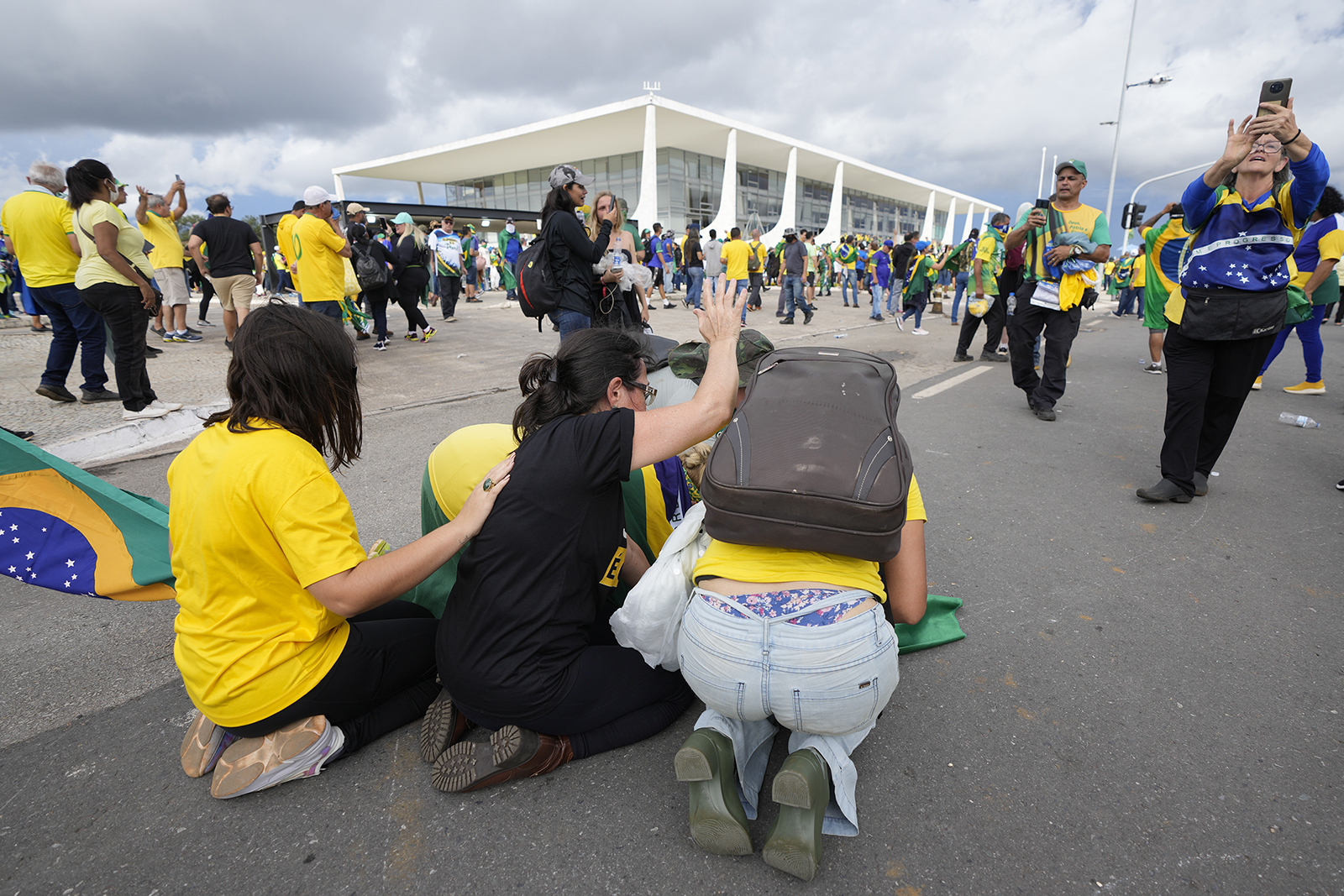 Supporters of Brazil's former President Jair Bolsonaro kneel to pray as they storm the Planalto Palace in Brasilia, Brazil, Sunday, Jan. 8, 2023. Planalto is the official workplace of the president of Brazil. (AP Photo/Eraldo Peres)