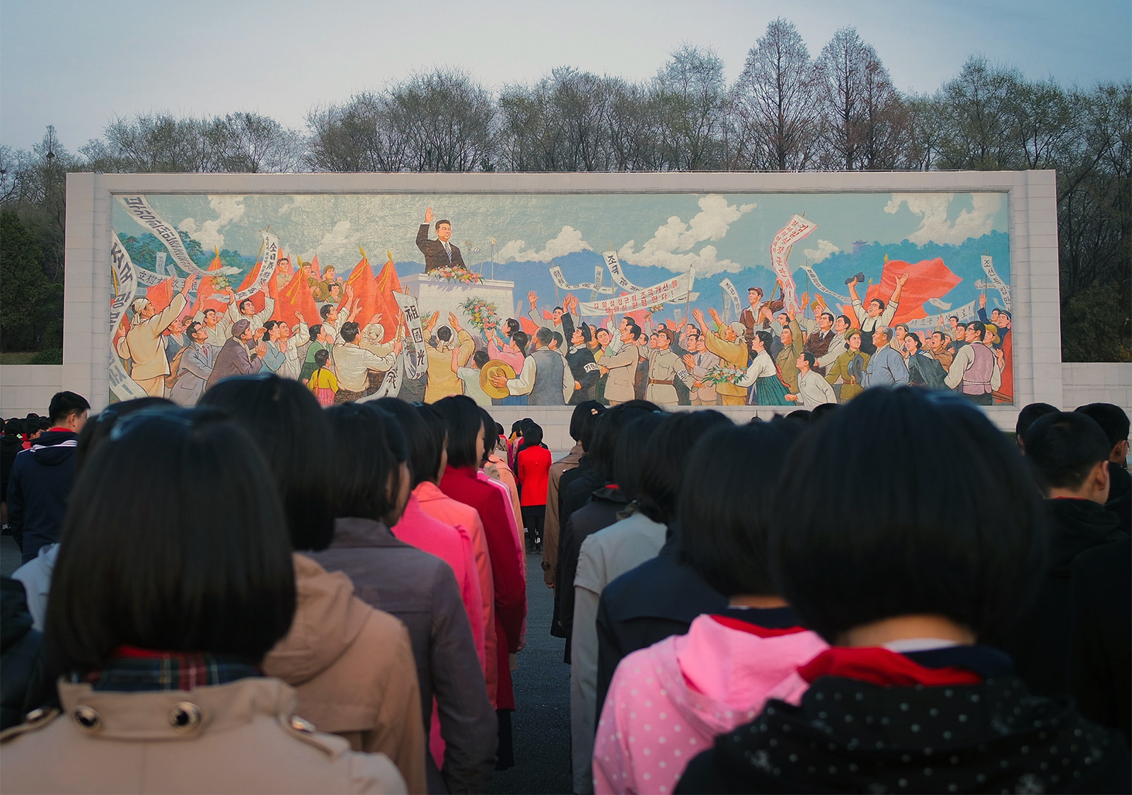 Children line up in front of a mural in Pyongyang, North Korea. Photo by Thomas Evans/Unsplash/Creative Commons